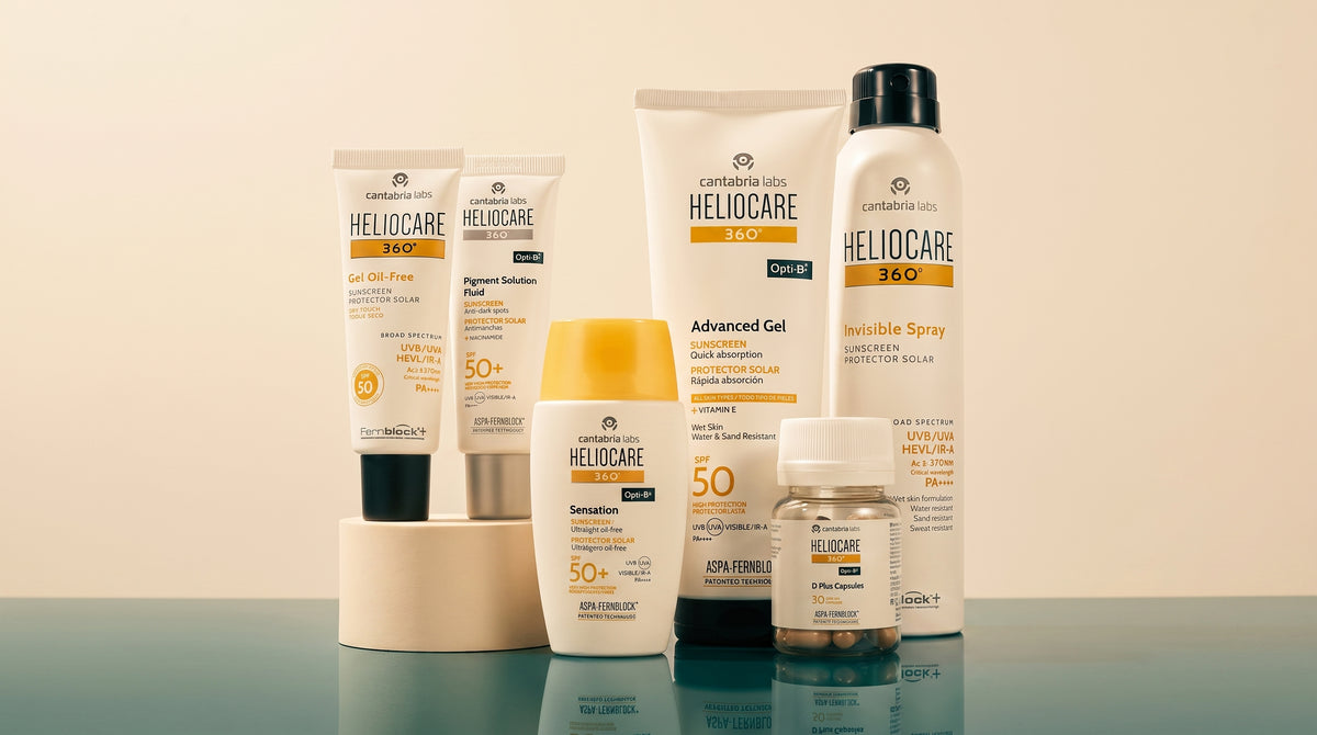 Heliocare 360 degree sun care range, including SPF gels, an SPF spray and oral capsules, arranged on a reflective surface against a cream background.