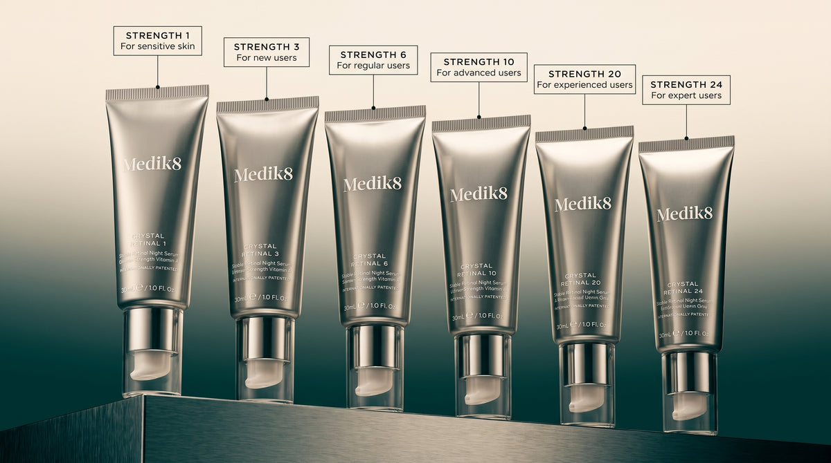 Six Medik8 Crystal Retinal tubes in ascending vitamin A strength, from Retinal 1 to Retinal 24, each labelled with its recommended user level, on a metallic gradient background.